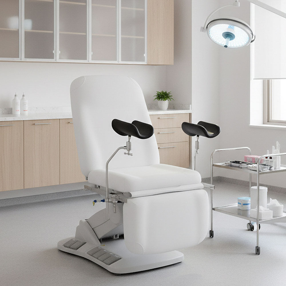 Medical examination chair in a clinical setting with cabinets and a light fixture.